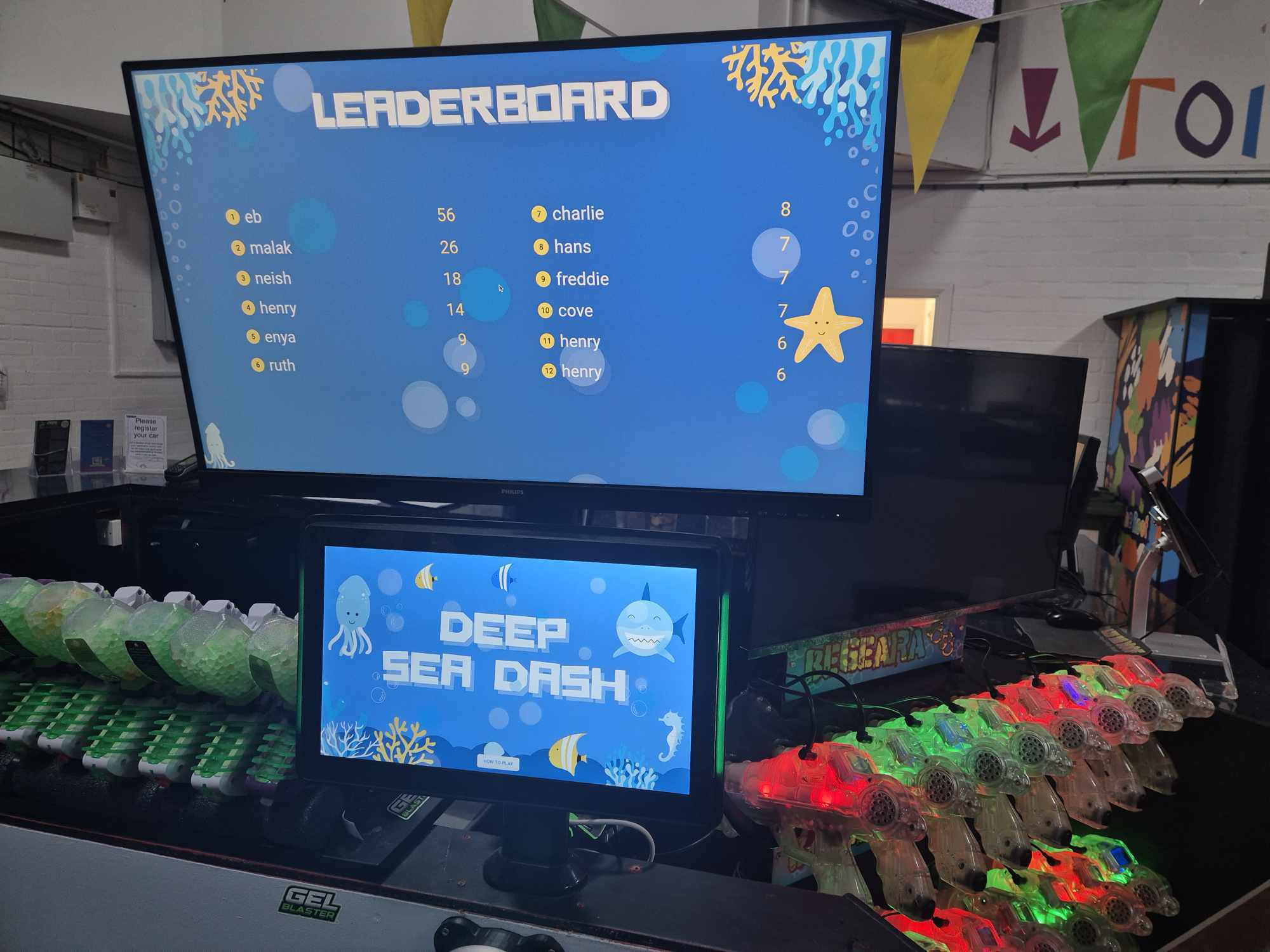 A leaderboard screen for deep sea dash. Underneath it is a touchscreen with Deep Sea Dash written on it. Under that is a Light Pad glowing blue. 